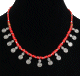 Collier artisanal imitation perles rouges corail agencees de perles argentees et autres en bois, agremente de petits pendentifs tourbillon en metal argente