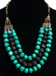 Collier ethnique artisanal imitation pierres turquoises noires et perles agencé de pièces argentées ciselées Collier ethnique artisanal imitation pierres turquoises noires et perles agencé de pièces argentées ciselées